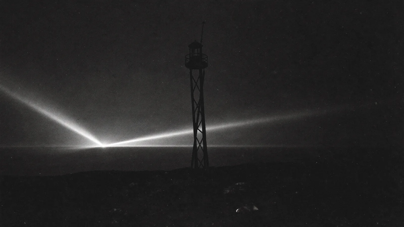 Tour de guet sur une falaise, faisceau de lumière balayant la mer de nuit, noir et blanc